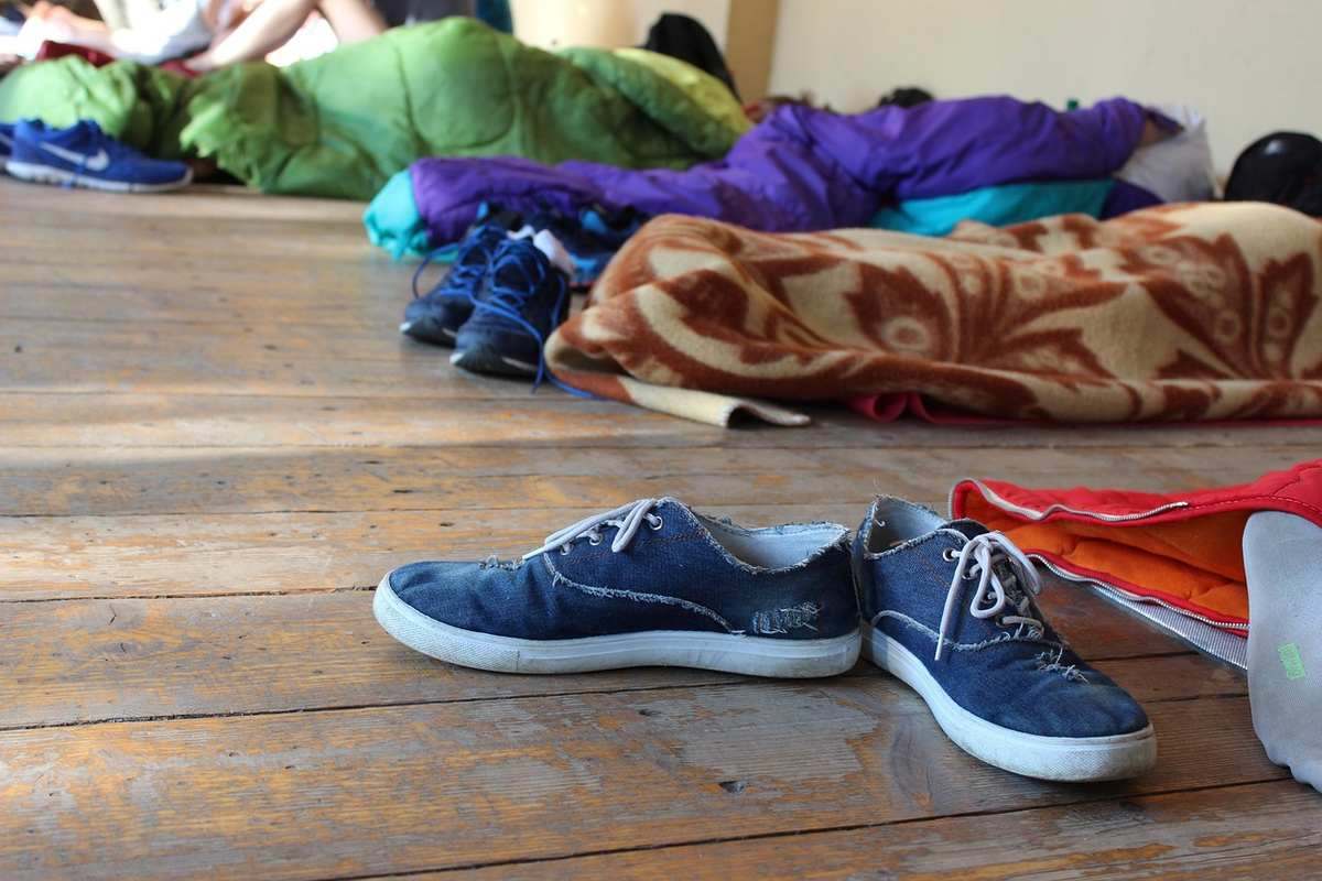 Chaussures de enfant et vêtements colorés disposés sur plancher en bois pour préparation voyage camping