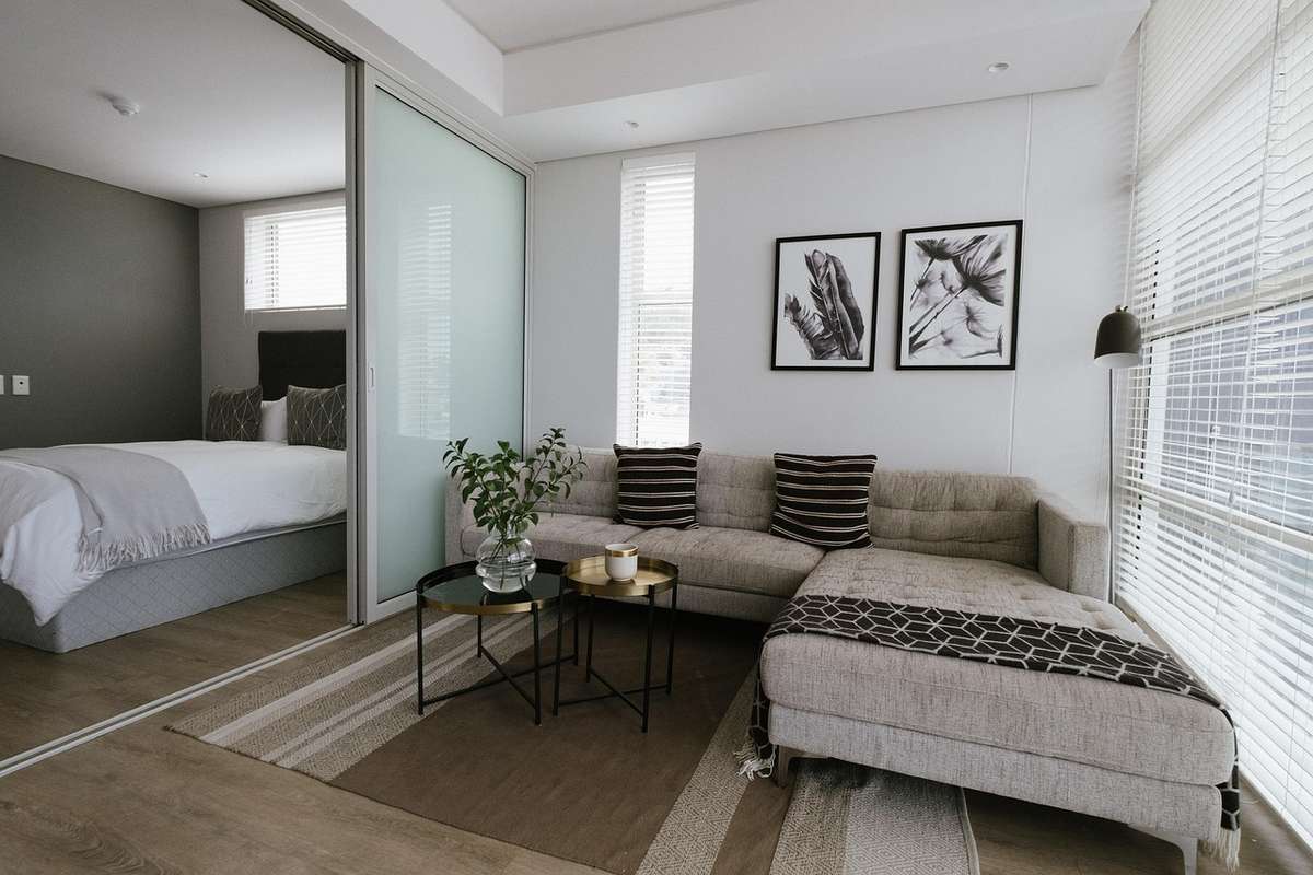 Une salle de séjour moderne avec canapé, table, lamp, fenêtre et lit Une salle de séjour moderne avec canapé, table, lamp, fenêtre et lit