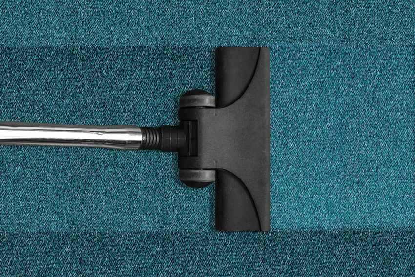 Buse d'aspirateur sur un tapis bleu