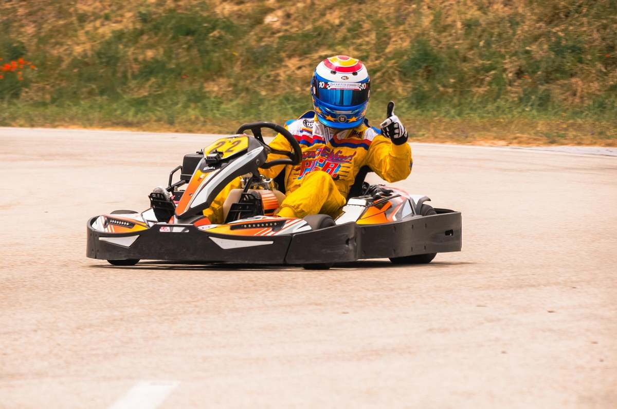 Un conducteur de karting donne un signe de victoire sur la piste Un conducteur de karting donne un signe de victoire sur la piste