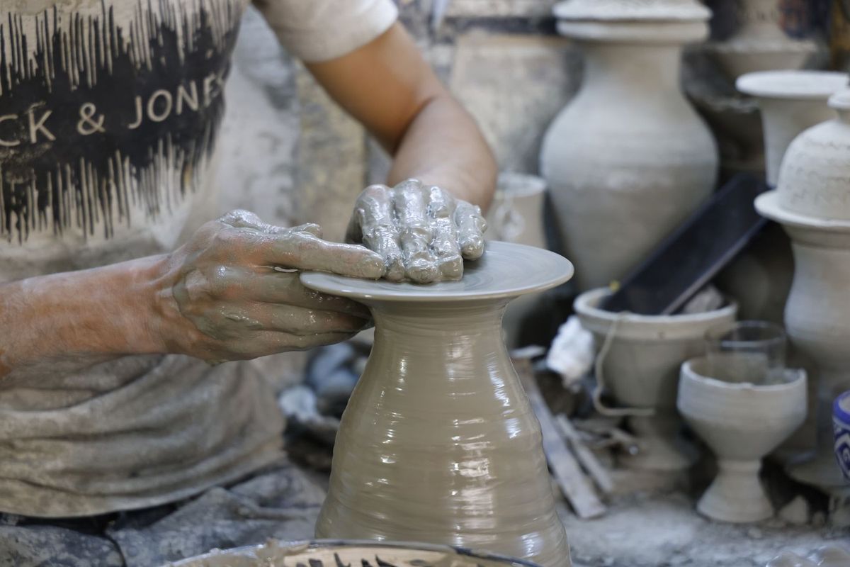 Artisan modelant de la terre sur un tour à l'atelier de poterie