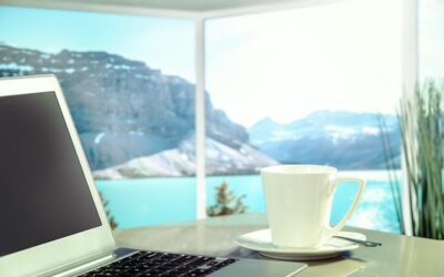 Ordinateur, tasse de café, table, vue sur lac et montagnes