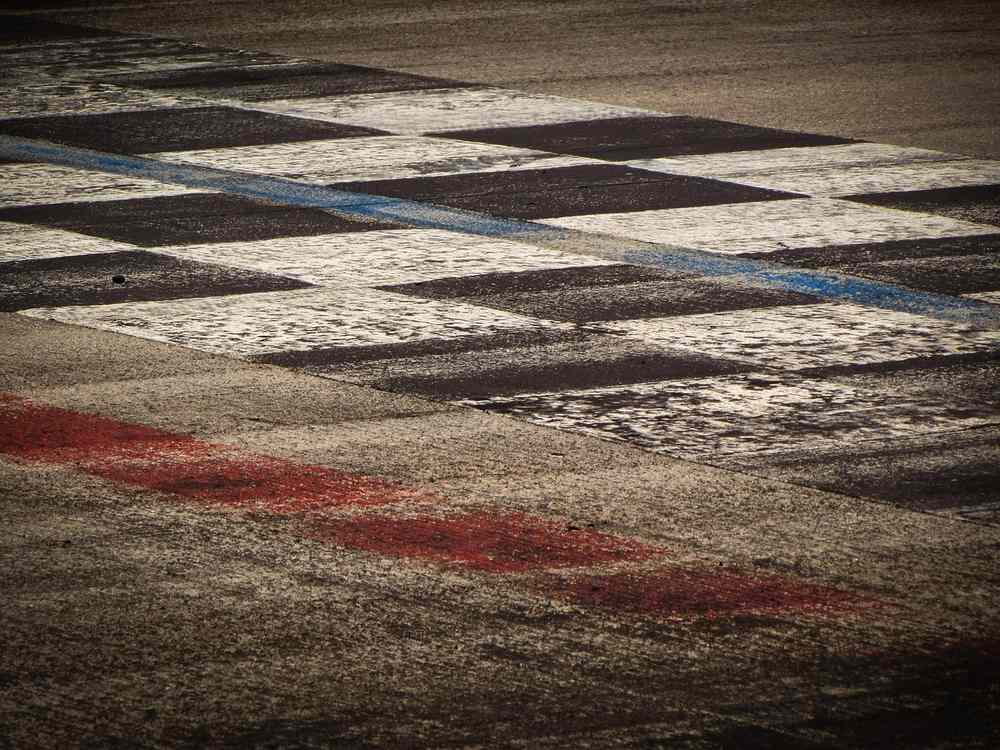 Tracé en damier sur asphalte, lignes bleue et rouge Tracé en damier sur asphalte, lignes bleue et rouge