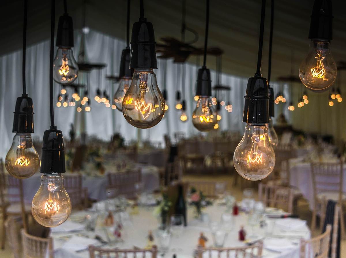 Suspension d'ampoules vintage éclairant une salle de banquet préparée