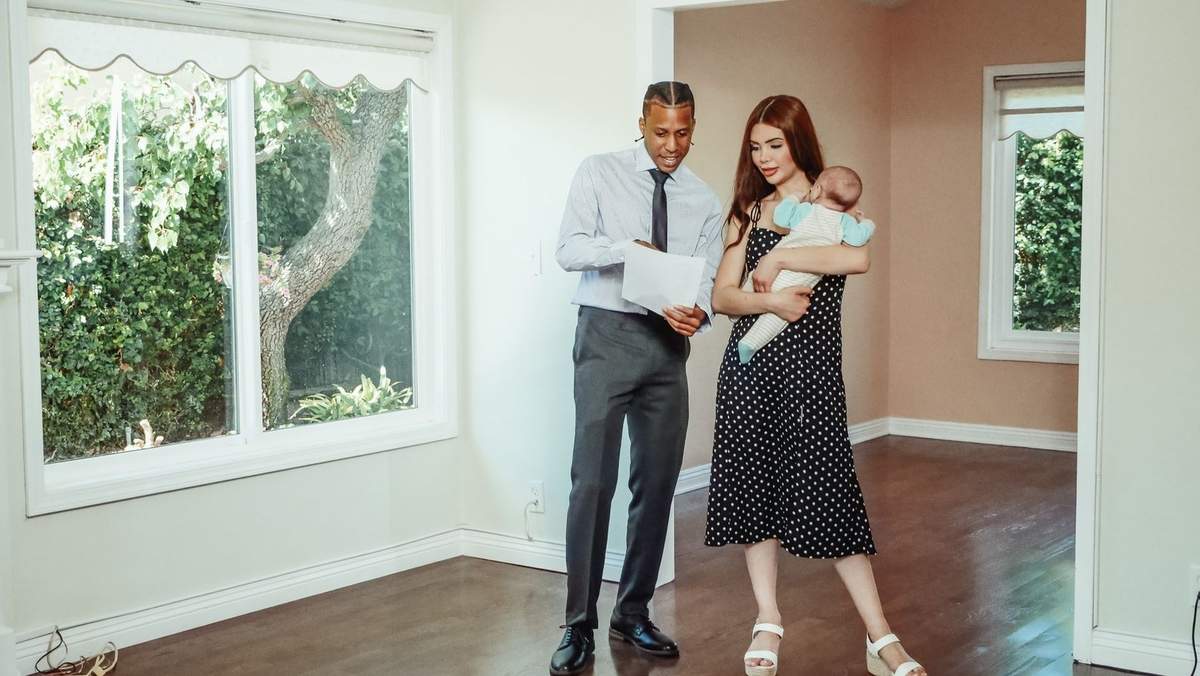 Couple et enfant visitent une maison avec un agent immobilier Couple et enfant visitent une maison avec un agent immobilier